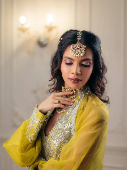 The complete Mehendi look, with soft, romantic makeup and beautifully styled hair. It’s a perfect blend of traditional elegance and modern charm.