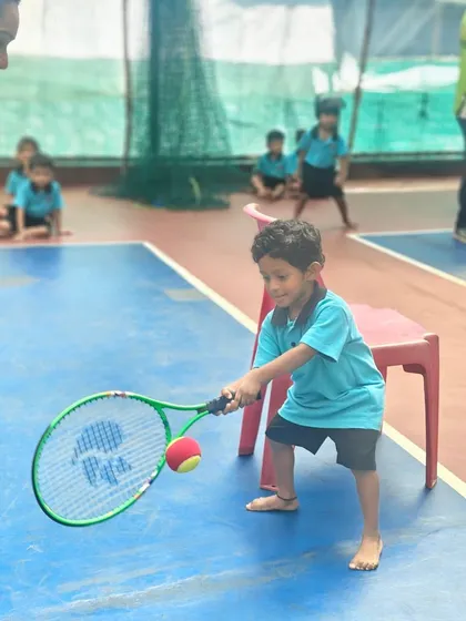 It all starts here. A young player in our Mini-Tennis program learns the fundamentals of a forehand, focusing on making clean contact with the ball. We make learning fun and effective from the very first swing.
