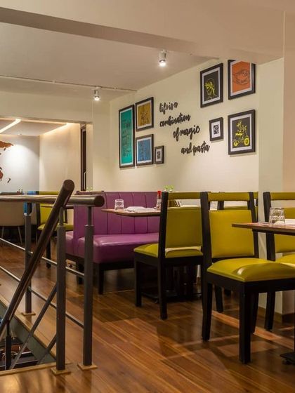 A view from the mezzanine level at the Cunningham Road location, looking down into another dining section. This split-level design creates distinct zones, with vibrant furniture and quirky wall quotes adding personality to the space.