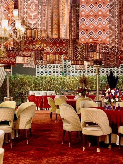 Another view of the opulent vintage decor, showing the rich layers of texture and color created by the hanging rugs and plush furnishings.