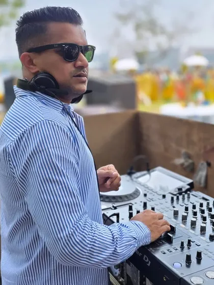 A candid shot of me at the console during a daytime mehndi in Goa. My focus is always on the music and the crowd's reaction.