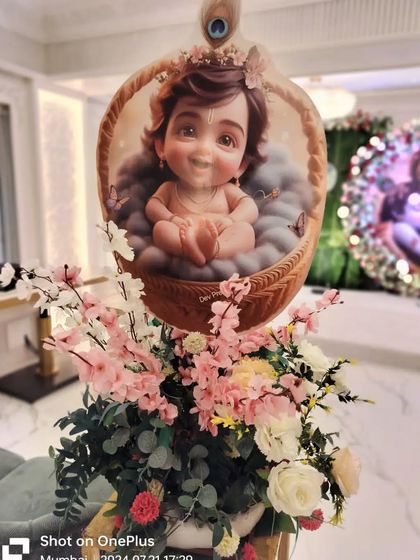A decorative floral stand featuring a baby Krishna cutout. These were placed along the aisle to enhance the theme throughout the event venue.