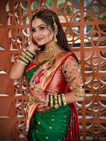 A candid shot of the bride in her green and red Paithani, looking radiant.