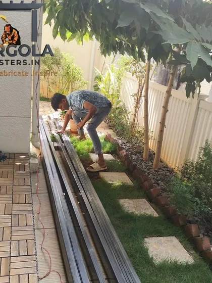 Metal beams for a new pergola project are laid out and prepared on-site. This shows the beginning stages of a custom build, where materials are organized and measured before fabrication begins.