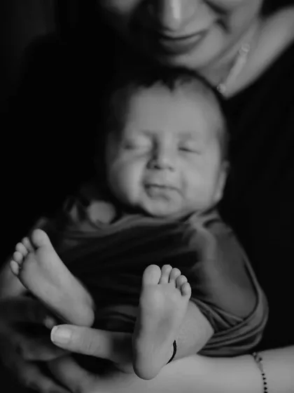 Sometimes, the smallest details hold the biggest love. This black and white portrait of a newborn's tiny feet held securely in their mother's hands is a powerful reminder of the precious, fleeting moments of infancy.