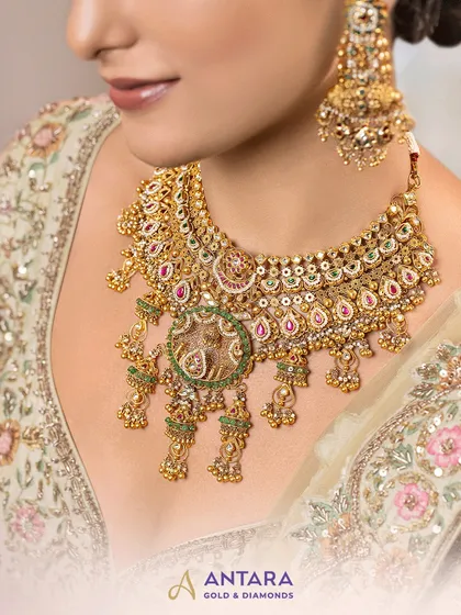 A closer look at the heart of our bridal collection. This exclusive choker, crafted in 22kt gold, showcases a fine Kundan setting, intricate meenakari detailing, and our signature jhumki drops, designed to frame your face with serene radiance.