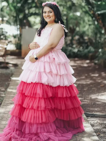 This mother-to-be is wearing our popular tri-color ombre gown with pink and red layers, a playful and eye-catching choice for an outdoor shoot.