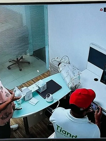 A clear, high-definition view from a CP Plus IP camera showing my team finalizing the setup at a desk. The image quality is sharp enough to see fine details.