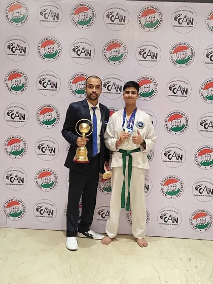 Celebrating a major win with my student, who is holding a championship trophy and his medals. Moments like these are a testament to his perseverance.