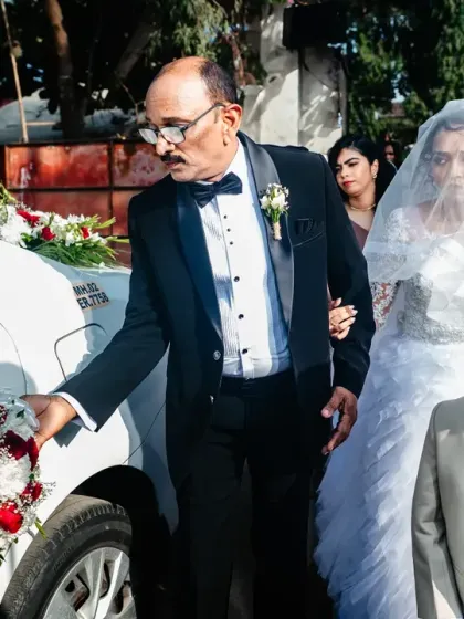 The bride, escorted by her father and a young page boy, makes her way to the church.