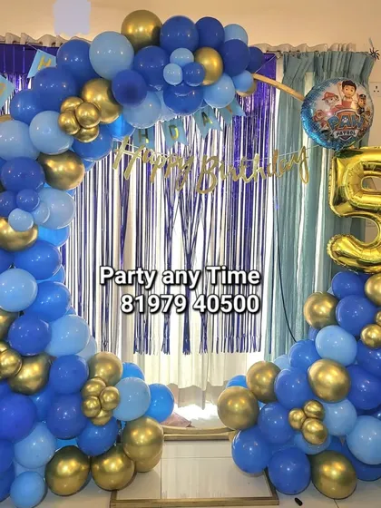 A blue and gold balloon arch for a 5th birthday party at home.