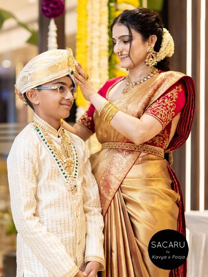 A heartwarming moment between mother and son, both dressed in custom Sacaru ensembles for the special occasion.