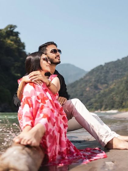 A relaxed moment on the riverbank, with the couple enjoying the sun and the view. This is a perfect example of a casual and comfortable pre-wedding portrait.