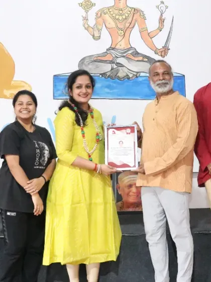 A student receives her certificate after completing the intensive 200-hour Ashtanga and Hatha TTC.