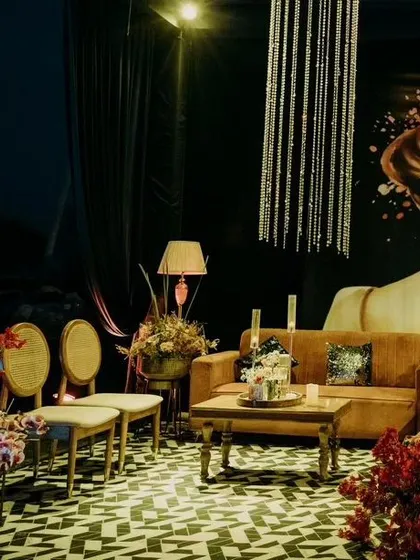 I create intimate and stylish lounge areas for guests to relax. This cozy corner features a plush sofa, elegant seating, and a dramatic art backdrop, all illuminated by a cascading crystal chandelier.