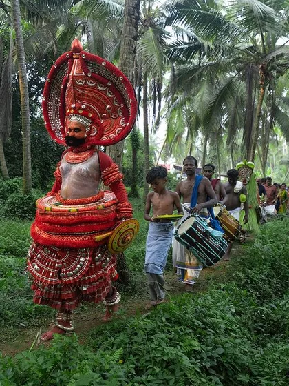 A Theyyam performer, considered a human god, makes his way through the lush greenery of Kerala. Documenting these ancient rituals involves following the entire journey, from the quiet preparations to the divine procession.