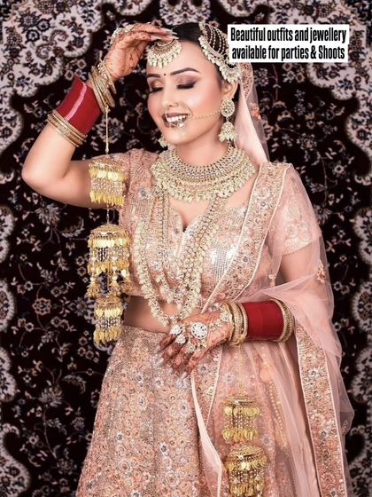 A happy bride in a peach-colored lehenga with heavy pearl and sequin work. The kalire and layered necklace complete her stunning bridal look.