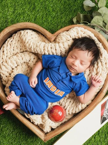 For the cricket-loving family, a newborn session featuring a tiny "India" jersey. The baby sleeps in a heart-shaped bowl surrounded by a bat, ball, and gloves.
