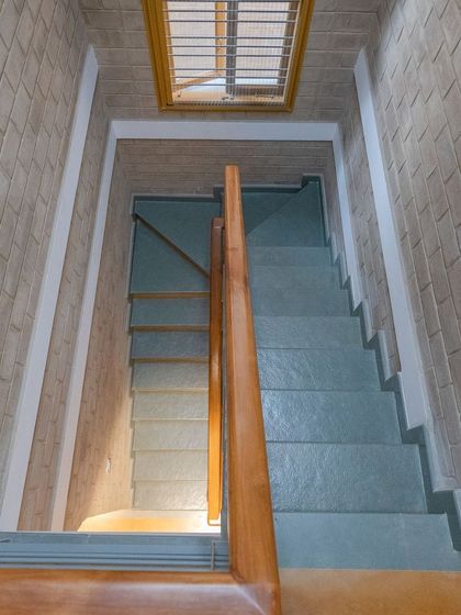 The staircase, lit from above by a skylight, creating a bright and airy passage.