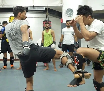 Two students exchange techniques during a light kickboxing spar. This is where you learn to manage distance, timing, and react to a live opponent.