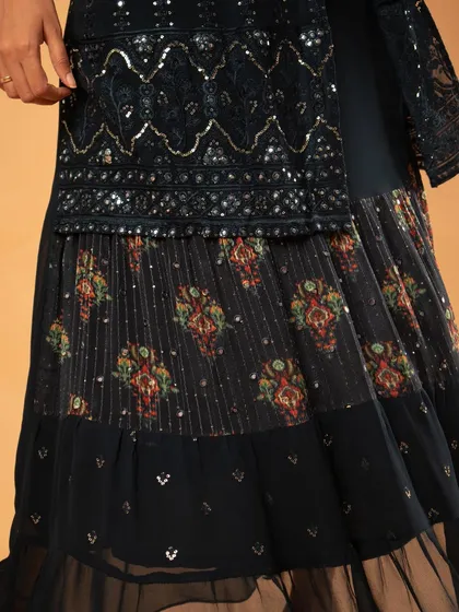 A close-up of the lower half of the dress, showing the layered patterns and textures.