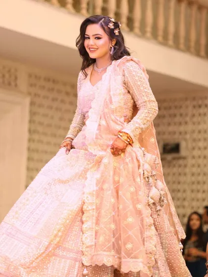 A twirl of happiness for this engagement bride. Her pink chikankari lehenga was complemented by a soft, romantic makeup look with loose curls and floral accessories, making her look like a princess.
