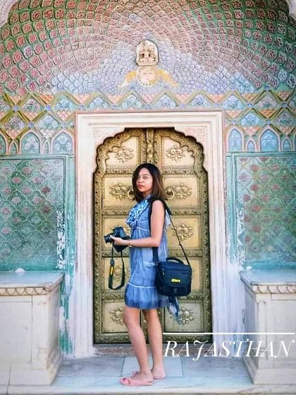 A traveler in front of the stunningly detailed gates in Rajasthan. Our trips celebrate the rich art and history found across India.