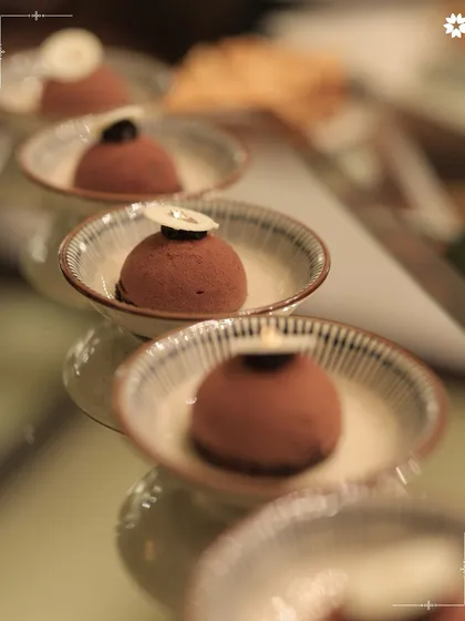 Individual chocolate mousse desserts, elegantly lined up for service. We bring the finesse of restaurant quality desserts to your home, ensuring a sweet and sophisticated end to your meal.