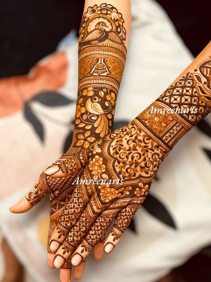 A designer Karvachauth mehndi with a mix of peacocks, florals, and geometric patterns.