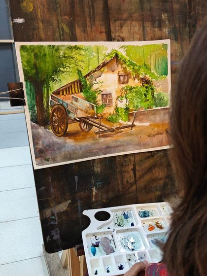 An over-the-shoulder view of the artist at work, providing a great perspective on the watercolor painting process.