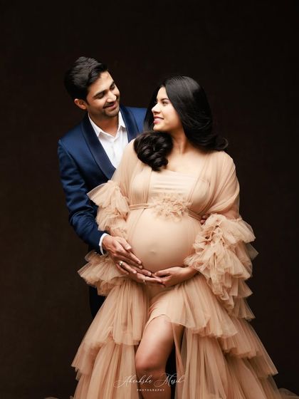 A classic couple's portrait that radiates happiness and love, as they both gently hold the baby bump.