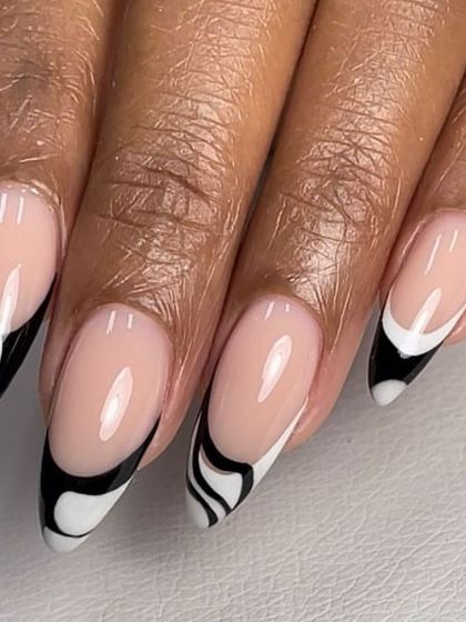 A creative black and white French tip design. The abstract swirl pattern gives this almond-shaped set a unique, artistic feel.