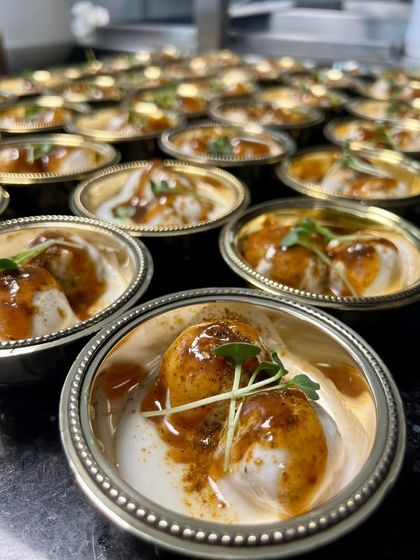 Miniature bowls of Dahi Bhalla, garnished with microgreens. This classic dish was served as part of the multi-course meal, presented in an elegant, modern style.