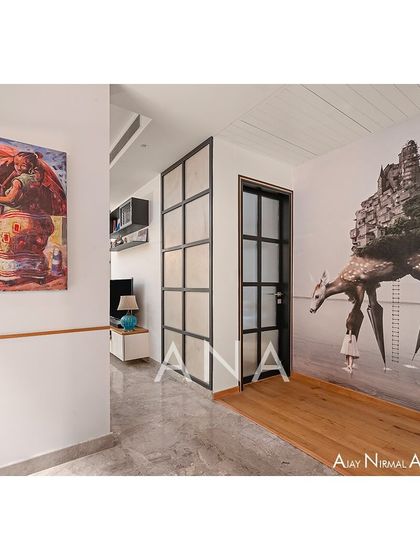 The entryway of Apartment 704 features a striking custom wallpaper, immediately setting a creative and contemporary tone. The design strategically uses art and texture to define spaces.