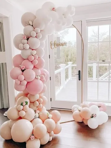 A delicate and airy balloon arrangement for a sophisticated celebration. The soft pink and white balloons on a thin golden arch create a minimalist and beautiful photo backdrop.