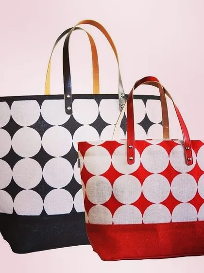 We manufacture premium jute tote bags in various sizes and designs, perfect for retail or high-end promotional use. This image displays two options from a single collection, featuring a bold geometric print in different color schemes and durable, stylish faux-leather handles.