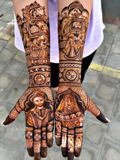 This grand bridal mehendi features regal portraits of the bride and groom. The arms are decorated with scenes of the doli and baraat, complete with elephants and shehnai players.