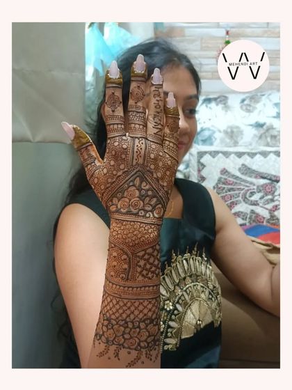 A happy client showing off her full-arm henna for a family wedding.