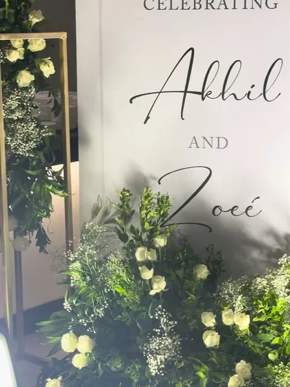 Another detail shot of the welcome sign and its surrounding floral arrangements. The combination of white flowers and lush greenery is a classic choice that never goes out of style.