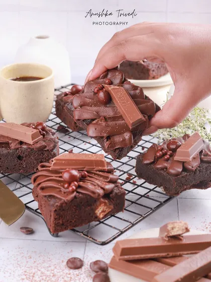 KitKat brownies are all about fun and indulgence. The action shot of a hand picking one up from the cooling rack makes it feel interactive and real.