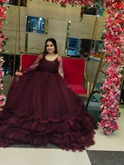 A princess moment in a voluminous burgundy tulle gown. This is a popular rental choice for engagements and pre-wedding shoots, paired here with soft makeup and loose curls.