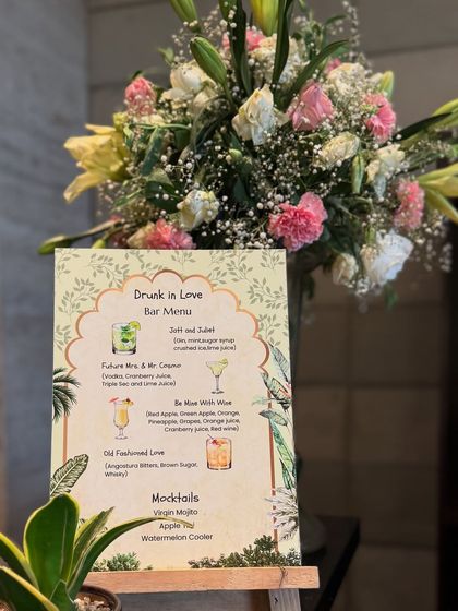 A custom bar menu designed for the "Drunk in Love" theme. We create personalized stationery that matches the overall decor, like this illustrated menu placed on an easel with a floral accent.
