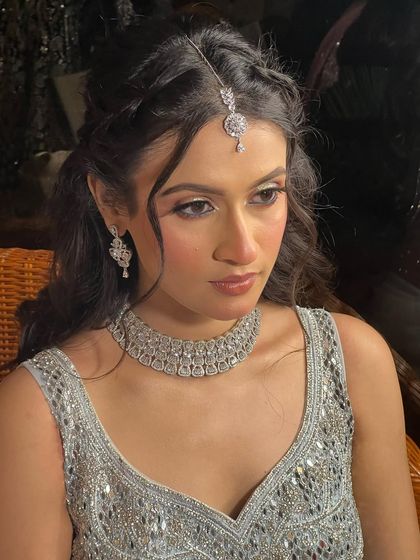 The bride-to-be looks stunning with her hair styled in a romantic half-updo, with soft tendrils framing her face.