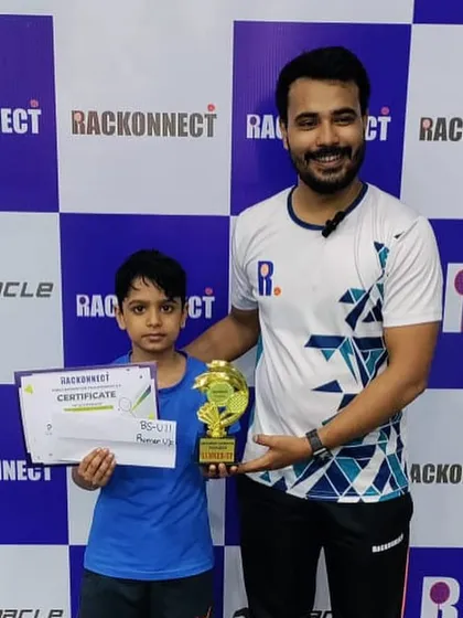 A proud moment for another young champion from my academy, posing with his coach and trophy after a successful tournament.