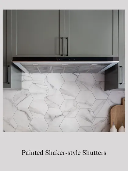 Painted shaker-style shutters in a calm grey tone, paired with a marble hexagonal backsplash. This combination is a timeless classic that feels both modern and sophisticated.