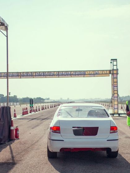 A white sedan at the starting line, with officials ready to signal the launch. The organization and professionalism are key to our events.