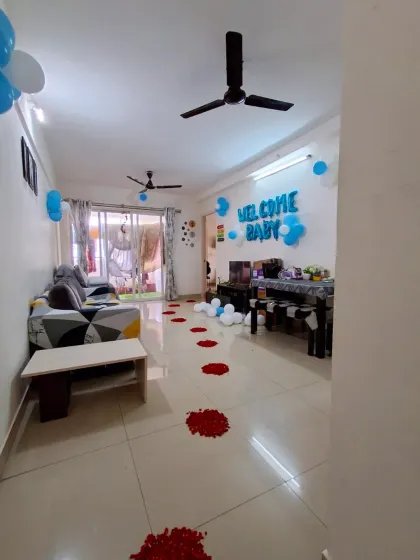 A full view of a "Welcome Baby" home decoration. I placed balloon arrangements, foil letters, and a path of rose petals leading into the living room.