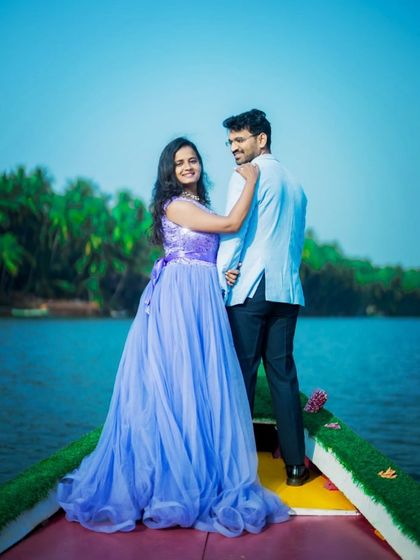 A happy and bright pre-wedding photo on a boat. The lavender-blue gown looks beautiful against the backdrop of the water and palm trees.