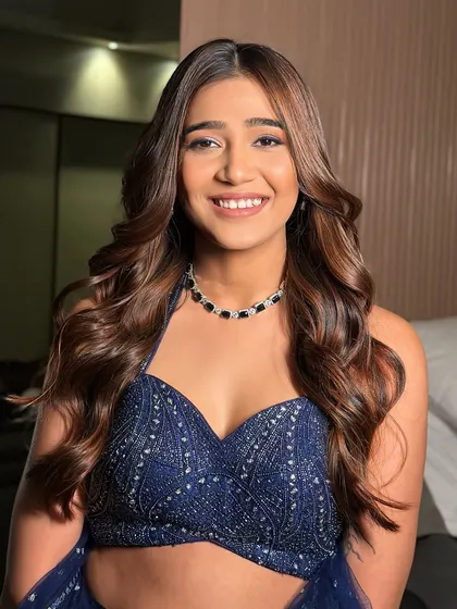 A beautiful, happy client with a fresh makeup look and soft, bouncy waves. This is a perfect look for a wedding guest or for a pre-wedding event.