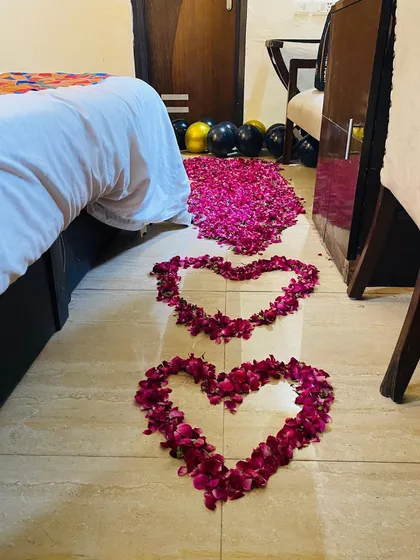 A close-up of the romantic details, with a trail of hearts made from fresh rose petals on the floor leading to the bed.